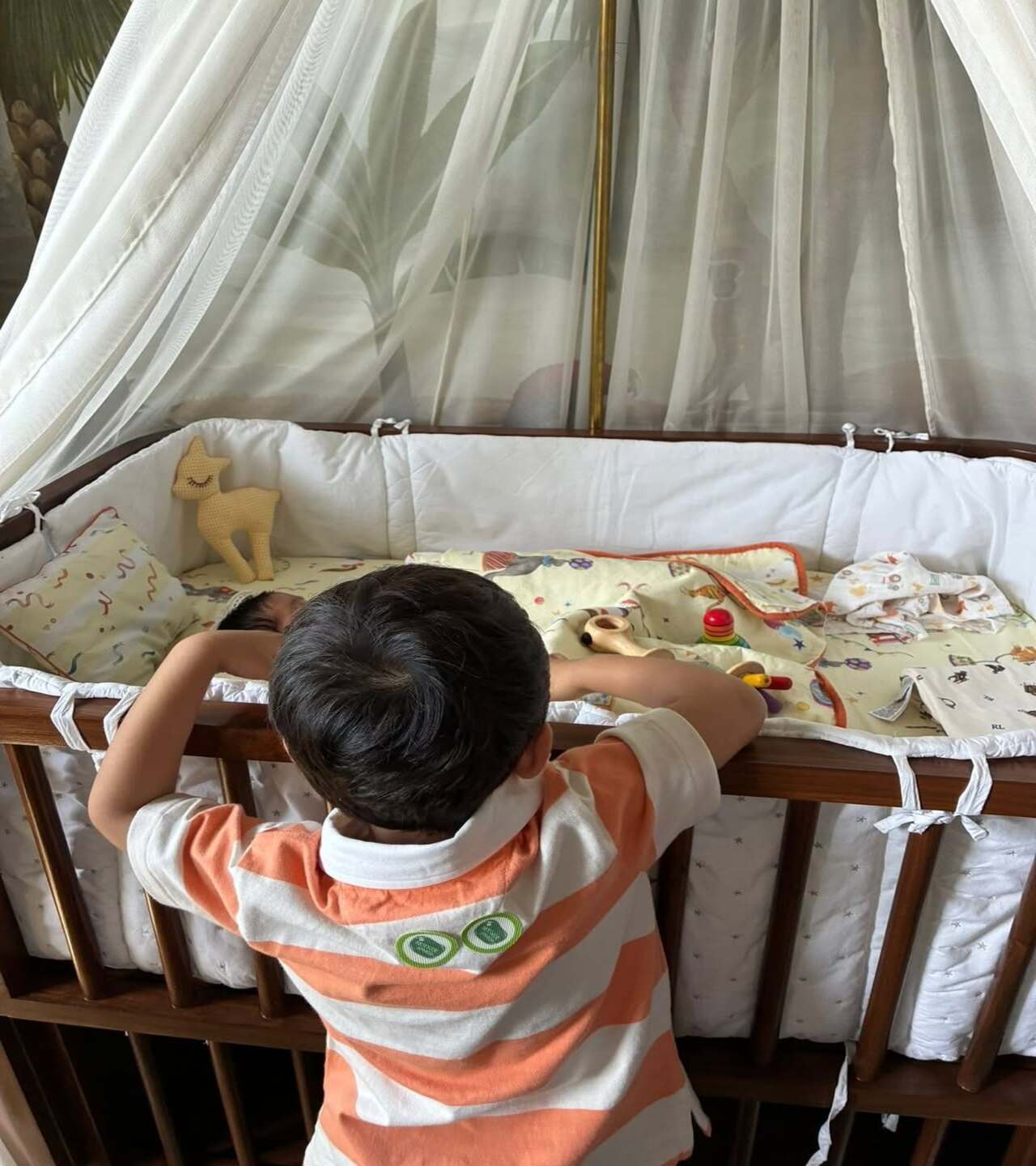 The heartwarming pic shows big-brother Vayu leaning against his little brother's cradle, observing him keenly as he sleeps. The newborn is wrapped snugly in a blanket